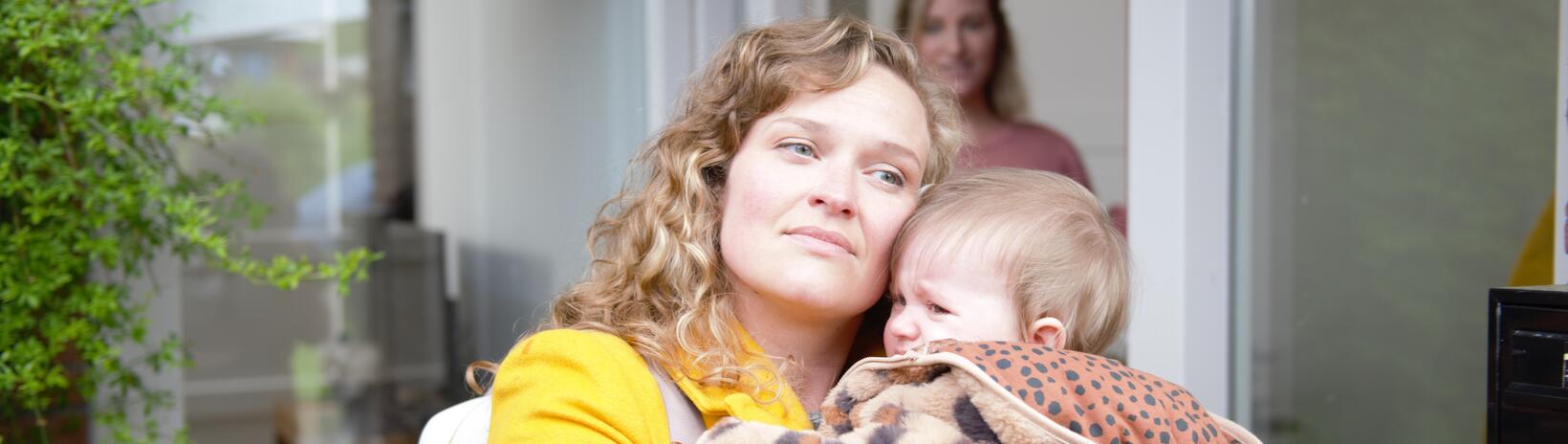 Moeder met dochter, andere moeder op de achtergrond